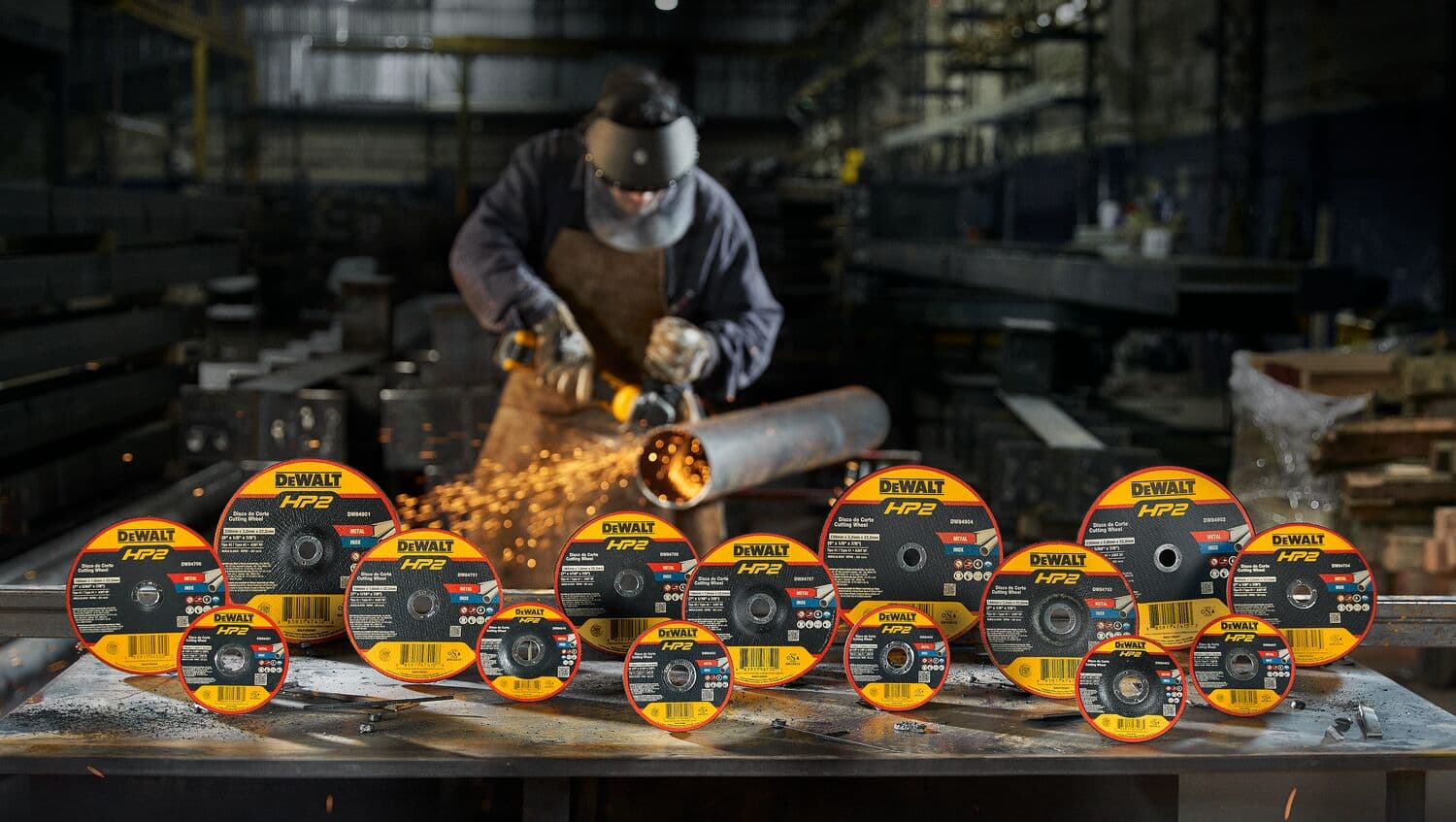 Productos de fotografía DEWALT SKUs 84705, 84401, 84410 en fábrica, trabajador lijando tubo de metal.