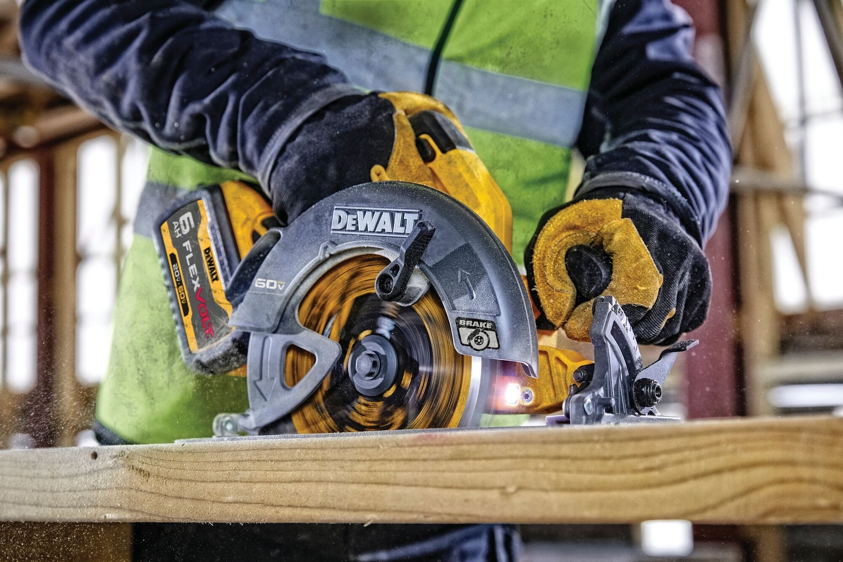 Una sierra circular inalámbrica DEWALT con batería FlexVolt 60V cortando una tabla de madera. Una persona con guantes y un chaleco de alta visibilidad está usando la sierra.