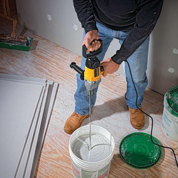 Half inch spade handle drill mixing concrete in a container.