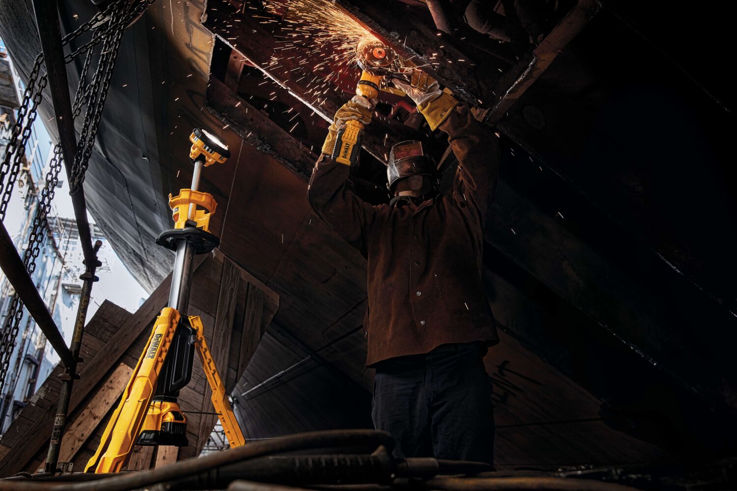 folded cordless tripod light being carried by a person at a construction site
