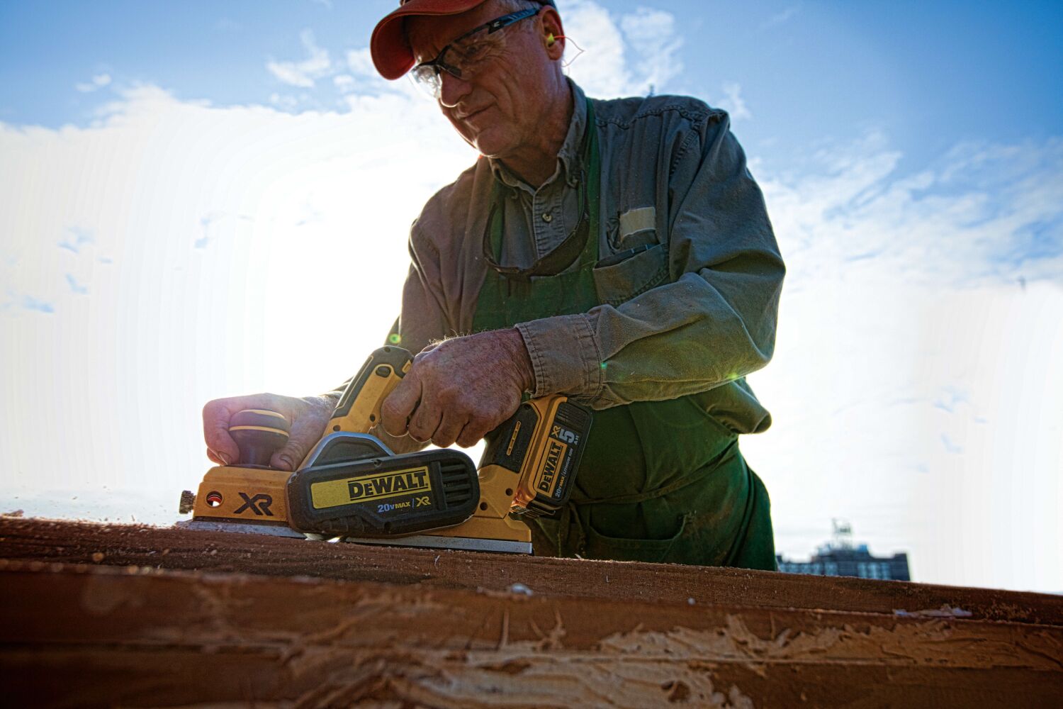 Brushless cordless planer being used by a person to ensure parallelism of cut.
